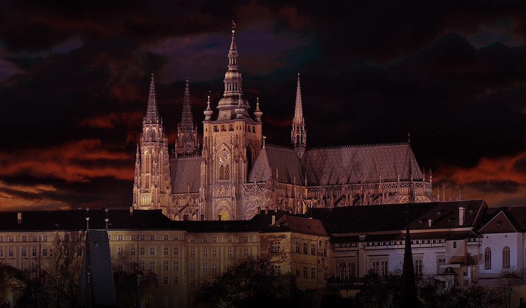 Prague castle and cathedral skyline at night under dark clouds
