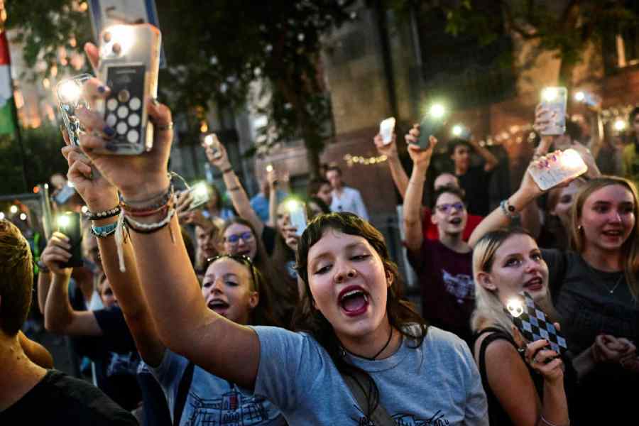 Young crowd in Sweden holding phones during a night-time public gathering